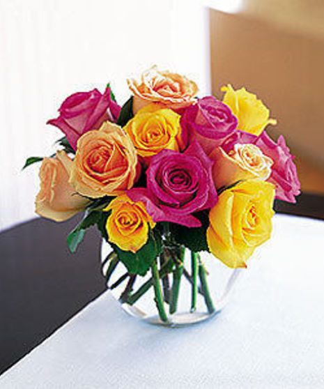 Multi colored roses in a bubble bowl vase.